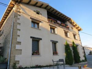 a large white building with windows and chairs in front of it at Herranetxe in Bóveda