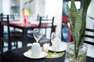 a table with two wine glasses and a candle on it at Htl & Suites Camino Real, ubicación, parking, facturamos in Colima