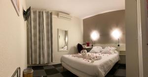 Un dormitorio con una cama con muñecas encima. en Le Relais de Gascogne, en Auch
