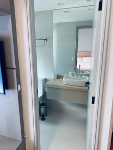 La salle de bains est pourvue d'un lavabo et d'un miroir. dans l'établissement Apart nos jardins, à São Paulo