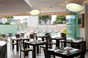 a restaurant with tables and chairs and a pool at Il Teatro in Lido di Jesolo