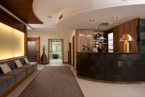 a lobby of a hotel with a woman standing at a counter at Il Teatro in Lido di Jesolo +23 photos