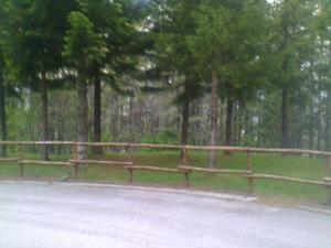 una valla de madera al lado de una carretera en appartamento Prato Verde I, en Pescasseroli