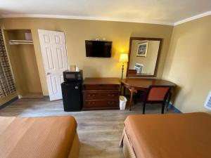 Habitación de hotel con 1 dormitorio con mesa y TV en Travel Inn Snyder, en Snyder