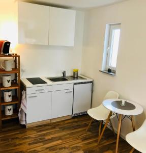 a small kitchen with a sink and a table at Top renoviertes Apartement in bester Lage von Homburg- 5 Fußminuten zur Uniklinik in Homburg