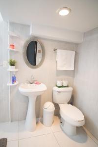 Baño blanco con aseo y lavamanos en Htl & Suites Camino Real, ubicación, parking, facturamos, en Colima