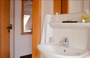 a white bathroom with a sink and a mirror at Boutique Hotel Selb in Selb