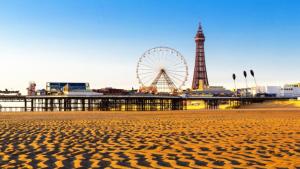 a beach with a ferris wheel in the background at MyRoomz Orchid Hotel in Blackpool