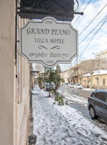 ein Schild für ein Grand Piano Viola Hotel in einer verschneiten Straße in der Unterkunft The Grand Piano Villa in Kutaissi