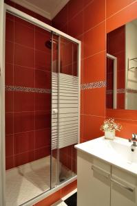 a red bathroom with a shower and a sink at Far Home Plaza Mayor in Madrid