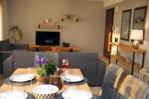 ネア・ペラモスにあるOnar Luxury Apartmentのリビングルーム(ワイン1杯付きのテーブル付)