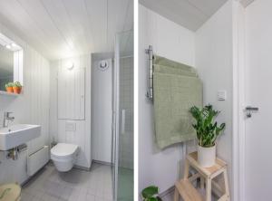 a white bathroom with a toilet and a sink at Sparkling newly built house close to city & nature in Stockholm +17 photos