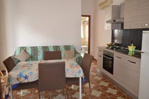 a kitchen with a table and chairs in a kitchen at casa Trieste in Scoglitti