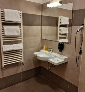 y baño con lavabo, espejo y toallas. en Life Sport Hotel, en Mentana
