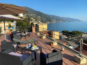a balcony with tables and chairs and a view of the ocean at L'ancora di Monterosso - Cinque Terre in Monterosso al Mare