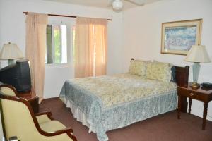 a bedroom with a bed and a television and a chair at Waterway Condos in Nassau