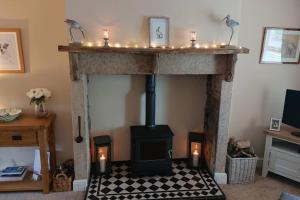 a fireplace with candles on top of it in a room at Number 7 The Cottage A Rural Retreat in Durham