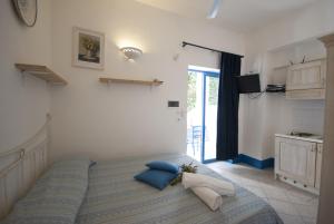 a bedroom with a bed with blue pillows at Villa Flora Studios & Apartments in Conca Specchiulla