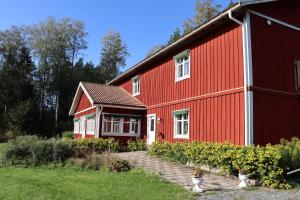 una casa rossa con tetto rosso di Skogsbrynet B&B, Bredsjö Nya Herrgård a Hällefors