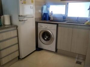 eine Küche mit einer Waschmaschine und einem Kühlschrank in der Unterkunft Apart Bicentenario in San Miguel de Tucumán