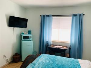 a bedroom with a bed and a table with a microwave at Blue House Miami in Miami Beach