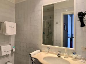 a white bathroom with a sink and a mirror at Villino Eleonora in Parghelia