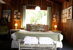 a bedroom with a large bed with a window at The Andiron Seaside Inn & Cabins in Little River