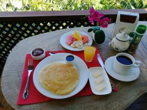 a table with a breakfast of pancakes and coffee and juice at La Guayaba Monteverde in Monteverde Costa Rica