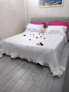 ein Schlafzimmer mit einem weißen Bett mit Rosen darauf in der Unterkunft Dante Street 49 in Neapel