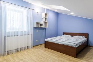 een blauwe slaapkamer met een bed en een raam bij VIP 2 floors apartmens on MAIN SQUARE in Lviv