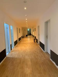 un pasillo vacío en un edificio de oficinas con suelo de madera en FischersPension, en Ahrensburg