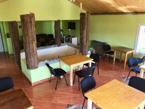 a room with tables and chairs and a couch at Hostel Familia de Campo in El Chalten