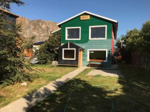 una casa con un jardín verde en Hostel Familia de Campo en El Chaltén