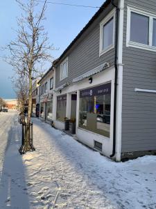 a snow covered street next to a building at Mosjøen Overnatting, Cm havigs gate 18 in Mosjøen