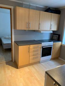 uma cozinha com armários de madeira e um forno com placa de fogão em Mosjøen Overnatting, Cm havigs gate 18 em Mosjøen