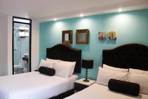 a hotel room with two beds and two lamps at La Casa del Viajero in Lima