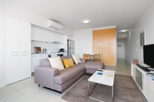 a living room with a couch and a kitchen at Ocean Views in Yeppoon