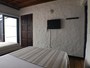 a bedroom with a white bed and white walls at Salento Pequeño Hotel in Salento