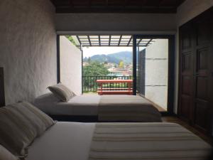 A bed or beds in a room at Salento Pequeño Hotel