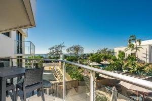 a patio area with a patio table and chairs at Bayview Beachfront Apartments in Byron Bay