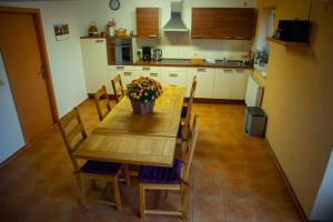 a kitchen with a wooden table with flowers on it at Gästehaus Schulz in Schenkendöbern