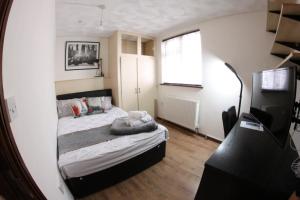 um pequeno quarto com uma cama e um espelho em College Street Abode em Portsmouth