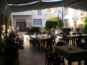 zewnętrzne patio ze stołami i krzesłami oraz budynek w obiekcie Luci del Golfo w mieście Alghero