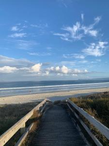 a stairway leading to a beach with the ocean at Thistle Do Beach Bach in Ruakaka