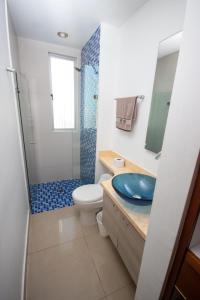 y baño con lavabo azul y ducha. en Excelente Apartamento Palmetto con vista al mar en Cartagena de Indias