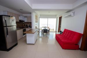 a living room with a red couch and a kitchen at Excelente Apartamento Palmetto con vista al mar in Cartagena de Indias