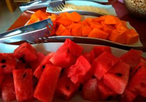 a plate of watermelon and carrots on a table at Hotel Chinchero Boutique & Tours in Chinchero +31 photos