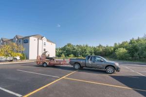 un camión tirando de un remolque en un estacionamiento en Microtel Inn & Suites by Wyndham Rice Lake, en Rice Lake