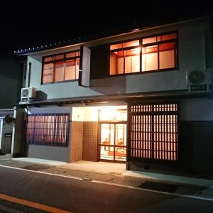 een gebouw met zijn deuren open in een straat 's nachts bij KINOSAKI KNOT in Toyooka