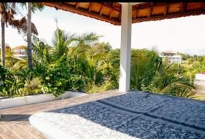 eine Veranda mit einem blauen Teppich auf einer Holzterrasse in der Unterkunft D'sawah Villa in Tanah Lot